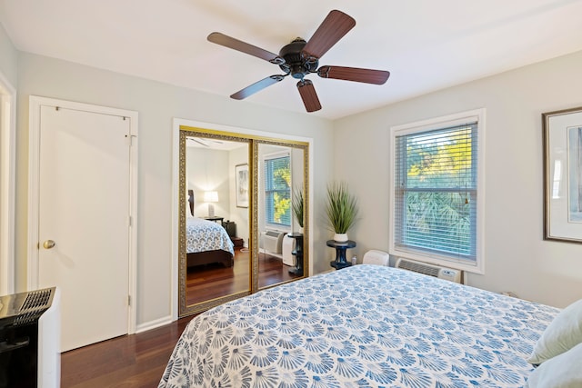 bedroom featuring a closet, a wall unit AC, ceiling fan, and dark wood-type flooring