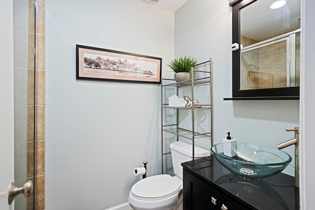 bathroom with vanity, toilet, and a shower with shower door