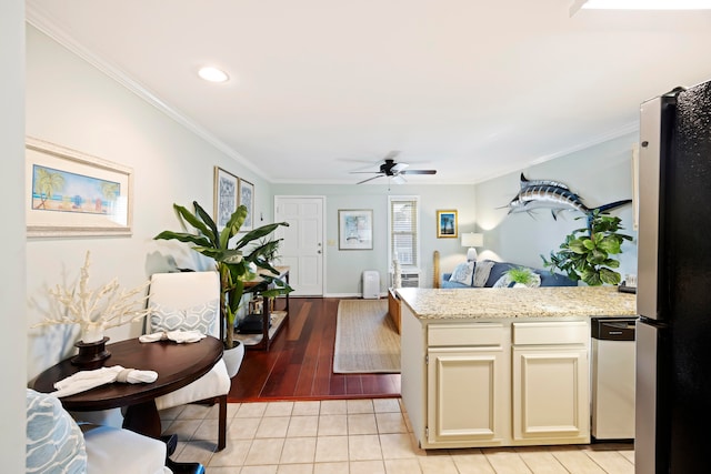 kitchen featuring ceiling fan, stainless steel appliances, crown molding, light hardwood / wood-style floors, and cream cabinetry