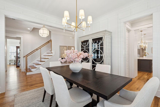 3858 Sawyers Island Dr, Mount Pleasant, SC 29466 - dining space featuring light wood-style flooring, ornamental molding, stairway, and a chandelier