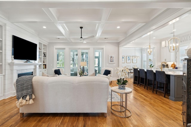 3858 Sawyers Island Dr, Mount Pleasant, SC 29466 - living room with coffered ceiling, beam ceiling, light wood finished floors, a fireplace, and ceiling fan with notable chandelier