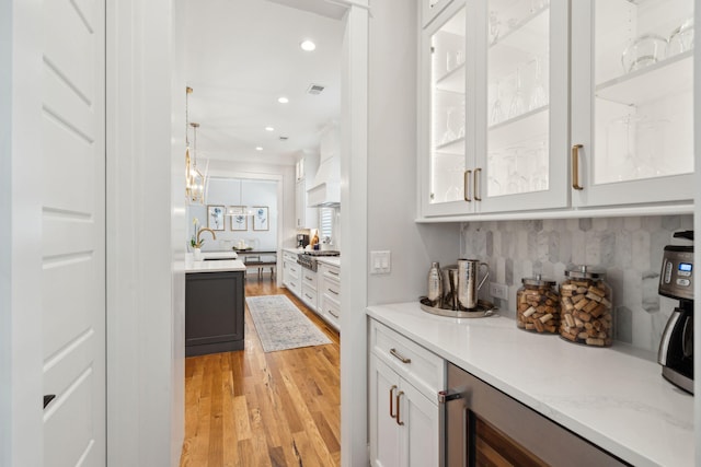 3858 Sawyers Island Dr, Mount Pleasant, SC 29466 - bar featuring a sink, tasteful backsplash, custom range hood, light wood-type flooring, and visible vents