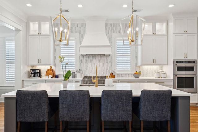 3858 Sawyers Island Dr, Mount Pleasant, SC 29466 - kitchen with custom range hood, light countertops, double oven, and an inviting chandelier