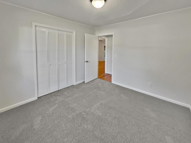 unfurnished bedroom with a textured ceiling, carpet floors, and a closet