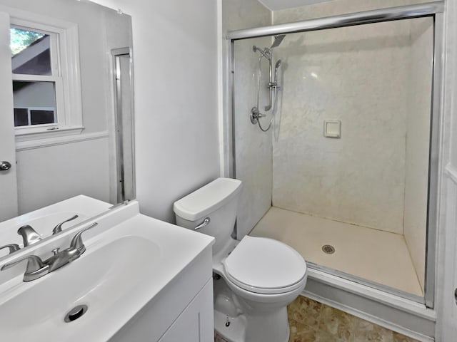 bathroom with a shower, vanity, and toilet