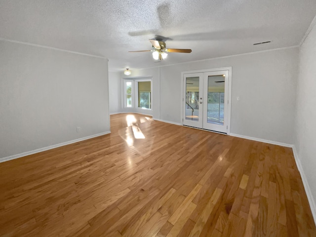 spare room with hardwood / wood-style flooring, ornamental molding, a textured ceiling, and french doors