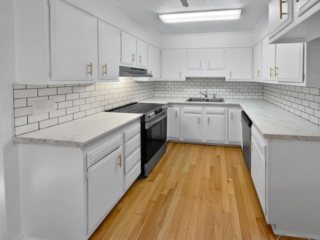 kitchen featuring white cabinets, sink, light hardwood / wood-style flooring, tasteful backsplash, and stainless steel appliances