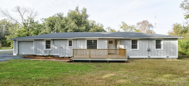 rear view of house featuring a lawn and a garage