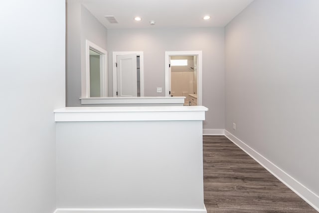 hallway with recessed lighting, visible vents, baseboards, and dark wood-style flooring