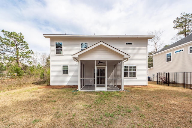 rear view of property with a ceiling fan, fence, a yard, and a sunroom