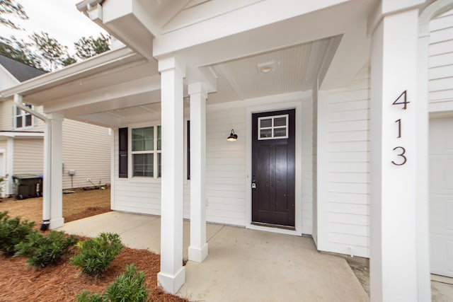 entrance to property featuring a porch and a garage