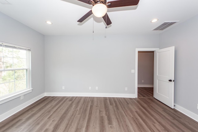 unfurnished room with visible vents, baseboards, and wood finished floors