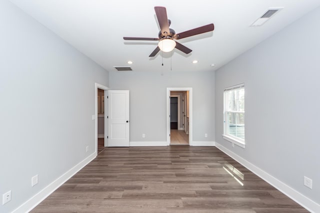 unfurnished bedroom with wood finished floors, recessed lighting, baseboards, and visible vents