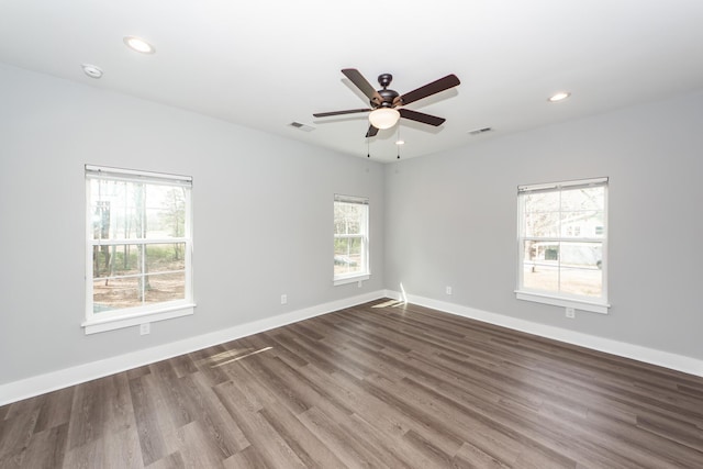 unfurnished room featuring wood finished floors, recessed lighting, baseboards, and visible vents