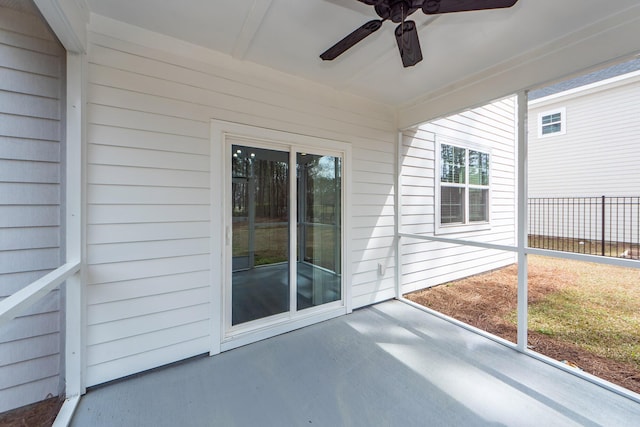 unfurnished sunroom featuring a ceiling fan