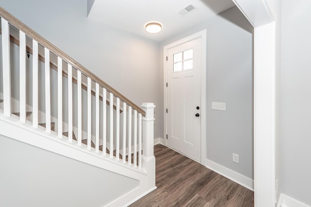 foyer featuring visible vents, wood finished floors, and baseboards