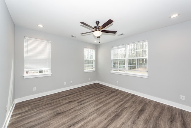 spare room with recessed lighting, visible vents, baseboards, and dark wood-style flooring