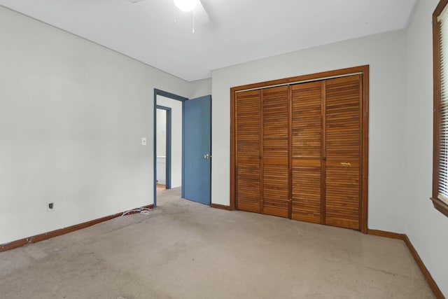 unfurnished bedroom with ceiling fan, a closet, and light carpet