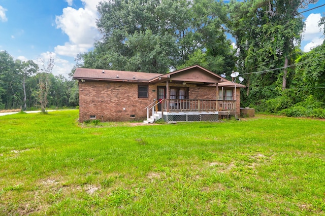 rear view of house with a wooden deck and a yard