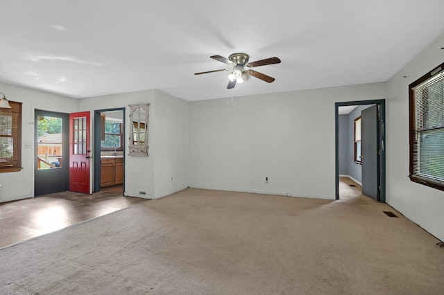 spare room featuring ceiling fan, light colored carpet, and sink