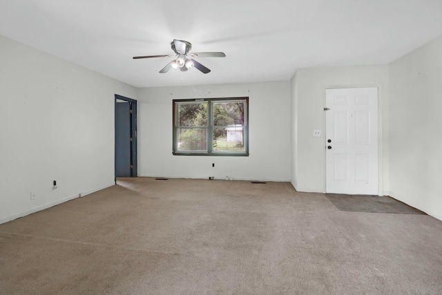 spare room featuring ceiling fan and light carpet