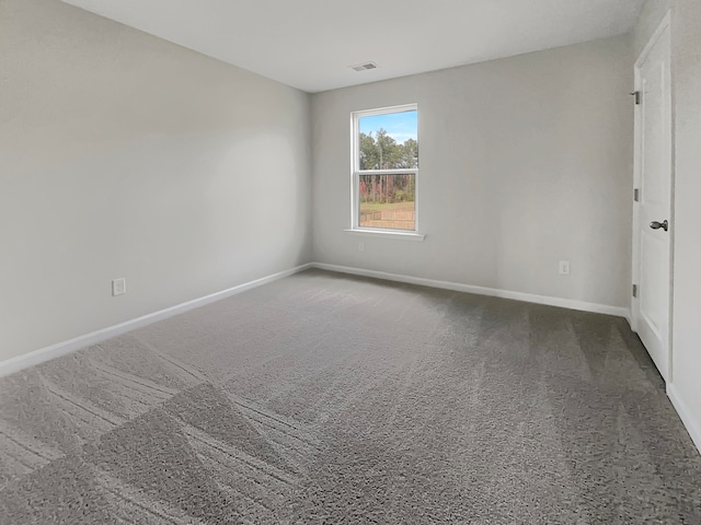 spare room with dark colored carpet