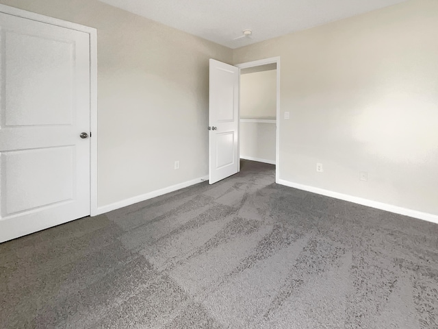 unfurnished bedroom with dark carpet