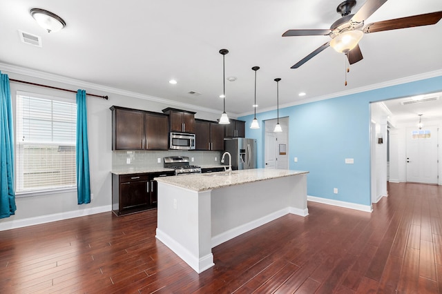 158 Netherfield Dr, Summerville, SC 29486 - kitchen with stainless steel appliances, dark brown cabinetry, an island with sink, backsplash, and dark wood finished floors