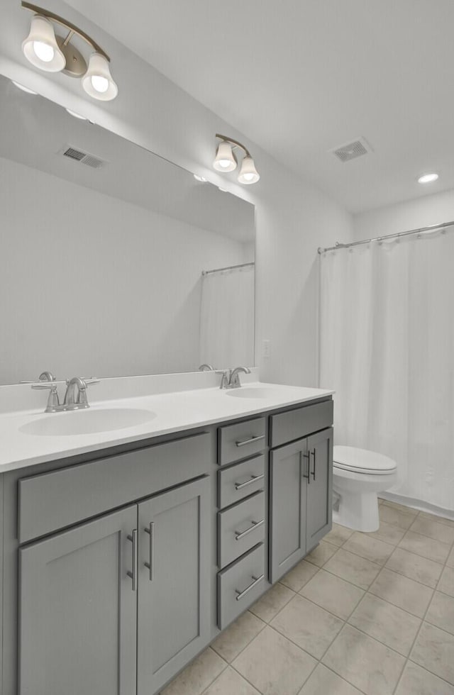 bathroom featuring toilet, curtained shower, tile patterned floors, and vanity