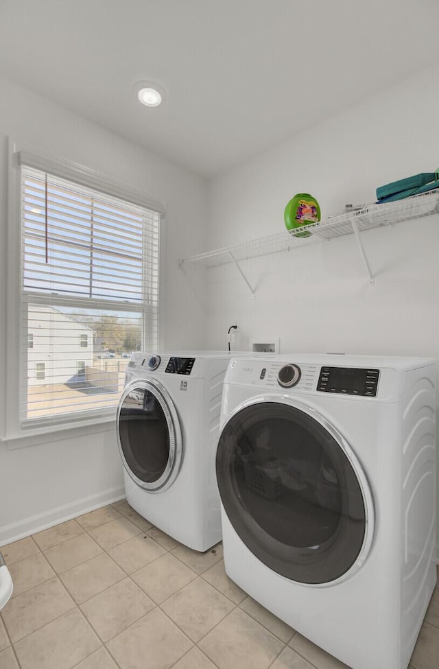 washroom featuring washing machine and dryer and light tile patterned floors