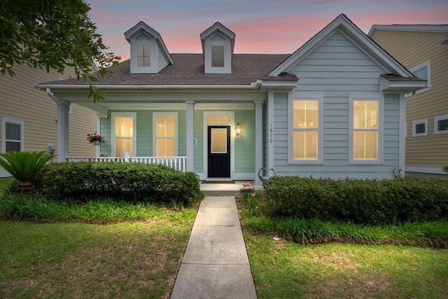1870 Gammon St, Charleston, SC 29414 - view of front facade featuring a porch, a front lawn, and roof with shingles
