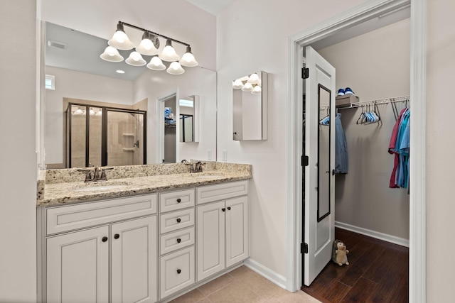 1870 Gammon St, Charleston, SC 29414 - bathroom featuring a stall shower, a walk in closet, double vanity, and baseboards