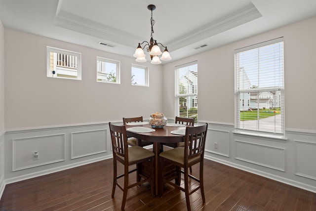 1870 Gammon St, Charleston, SC 29414 - dining room featuring a tray ceiling, a chandelier, ornamental molding, dark wood-style floors, and wainscoting