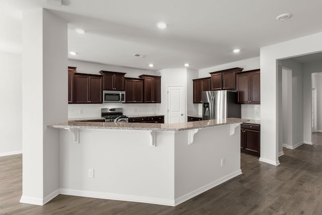 341 Witch Hazel St, Summerville, SC 29486 - kitchen with appliances with stainless steel finishes, a breakfast bar area, baseboards, light stone countertops, and recessed lighting