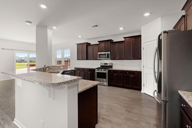 341 Witch Hazel St, Summerville, SC 29486 - kitchen featuring stainless steel appliances, light wood-style flooring, a breakfast bar area, a sink, and tasteful backsplash