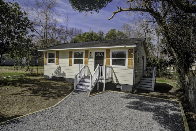 view of front of home featuring crawl space and fence