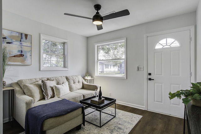 living area with ceiling fan, baseboards, and dark wood-style flooring