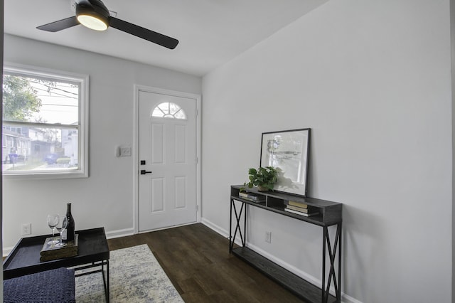 entryway with ceiling fan, dark wood-type flooring, and baseboards