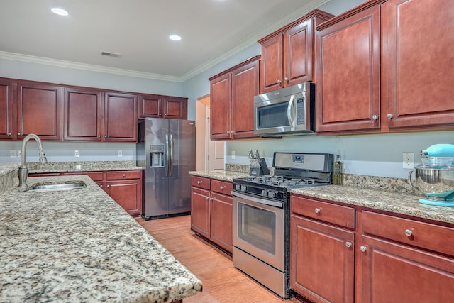 kitchen with light stone counters, stainless steel appliances, crown molding, light hardwood / wood-style flooring, and sink