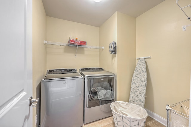 laundry room with washing machine and dryer and light tile patterned flooring