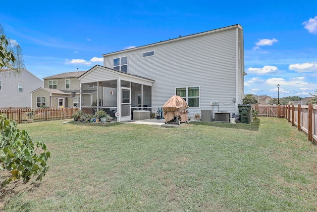 back of property with a sunroom, a yard, a patio, and central air condition unit