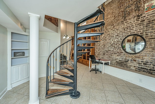 stairs with brick wall, ornate columns, tile patterned flooring, ceiling fan, and built in features