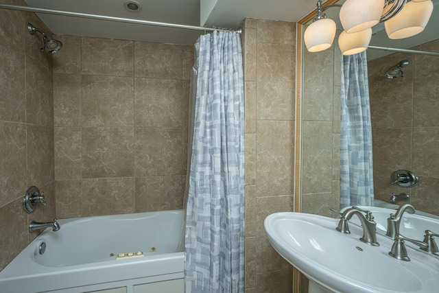 bathroom with tile walls, sink, and shower / tub combo with curtain