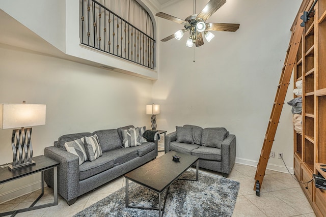 tiled living room with ceiling fan and a high ceiling