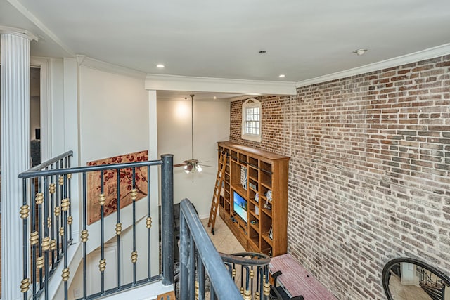 corridor with ornate columns, crown molding, and brick wall