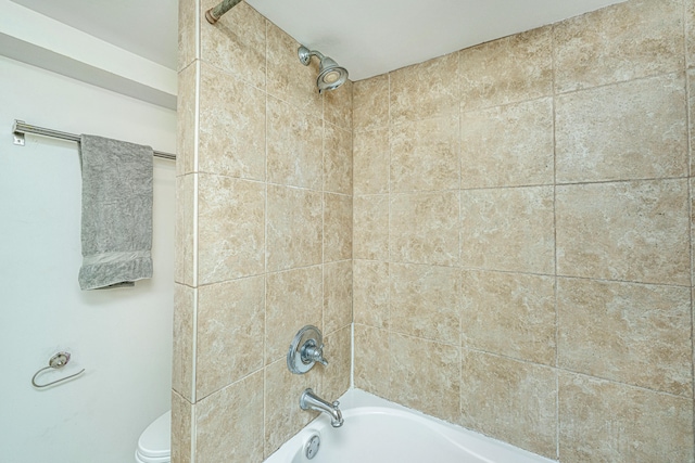 bathroom featuring tiled shower / bath combo and toilet