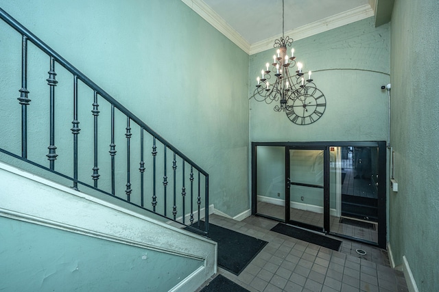 tiled foyer with crown molding and an inviting chandelier