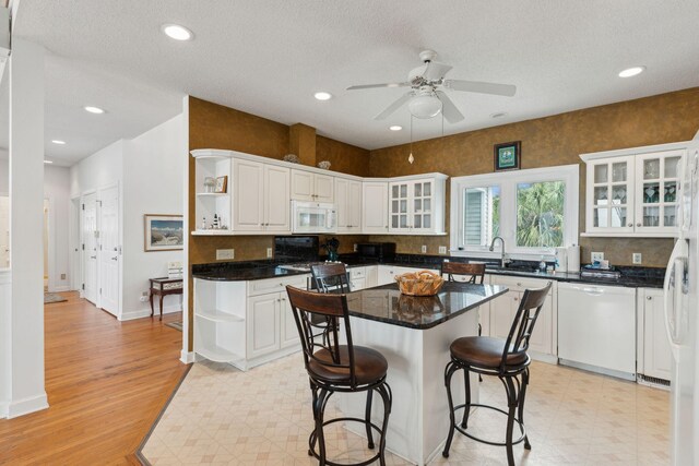 505 E Arctic Ave, Folly Beach, SC 29439 - kitchen with open shelves, white appliances, white cabinets, a ceiling fan, and a kitchen island
