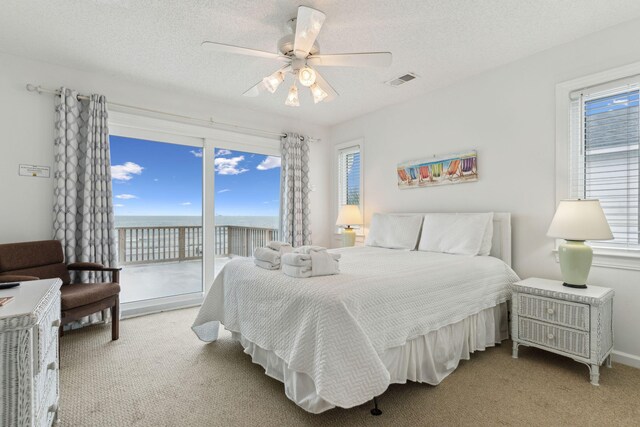 505 E Arctic Ave, Folly Beach, SC 29439 - carpeted bedroom featuring access to outside, multiple windows, a water view, ceiling fan, and a textured ceiling