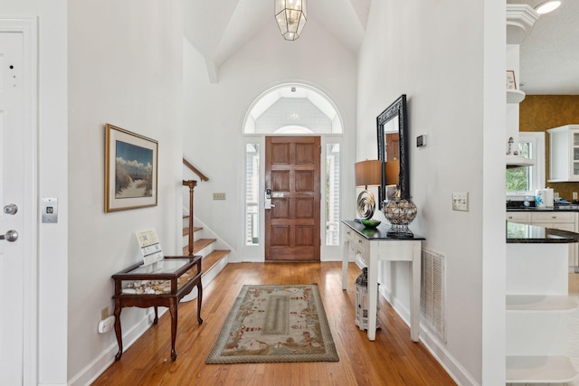 505 E Arctic Ave, Folly Beach, SC 29439 - entrance foyer featuring wood finished floors, stairs, and high vaulted ceiling